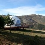 a white dome sitting on top of a lush green hillside