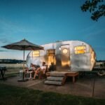 man and woman sitting in front of RV trailer