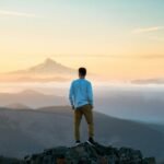 man standing on top of mountain