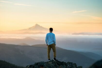 man standing on top of mountain