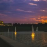 a sunset view of a building and a fountain