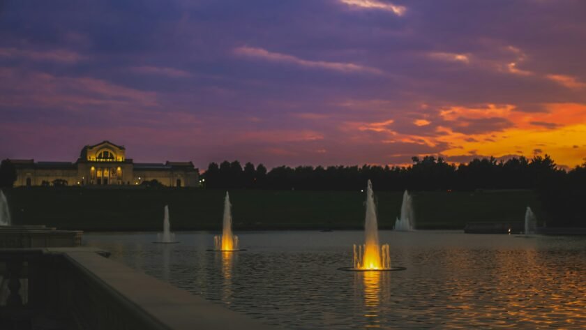 a sunset view of a building and a fountain