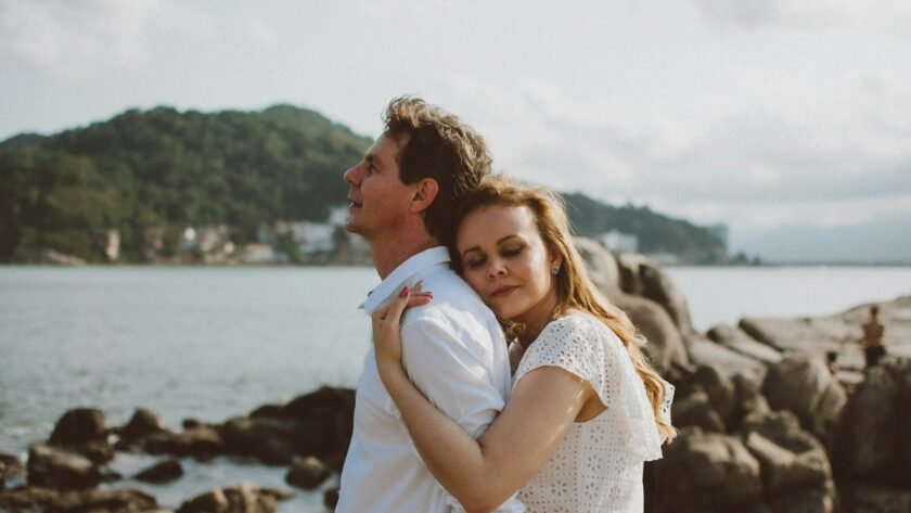 a man and a woman standing next to a body of water