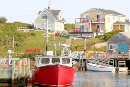 red and white boat on body of water near houses during daytime