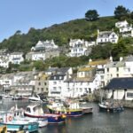 a harbor filled with lots of boats next to a hillside