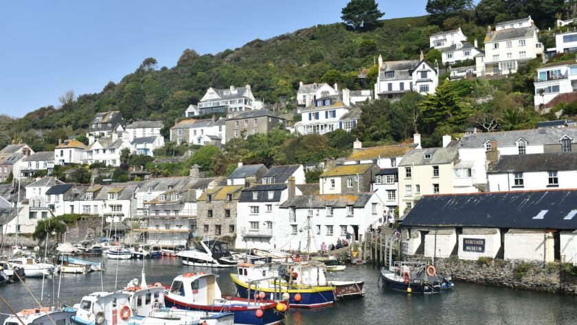 a harbor filled with lots of boats next to a hillside